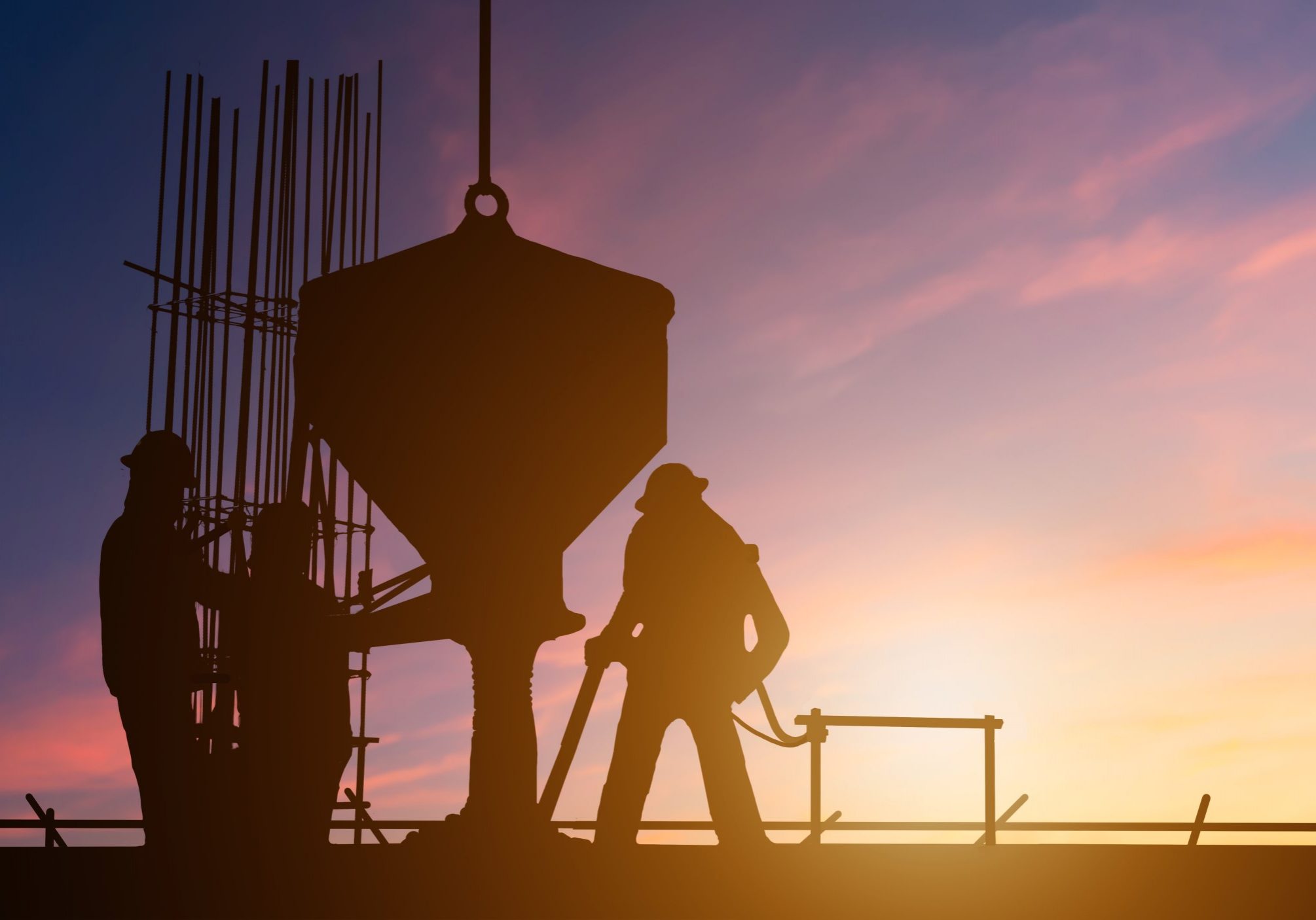 silhouette-teams-worker-construction-pouring-concrete-construction-sites-through-blurry-construction-sites-sunset