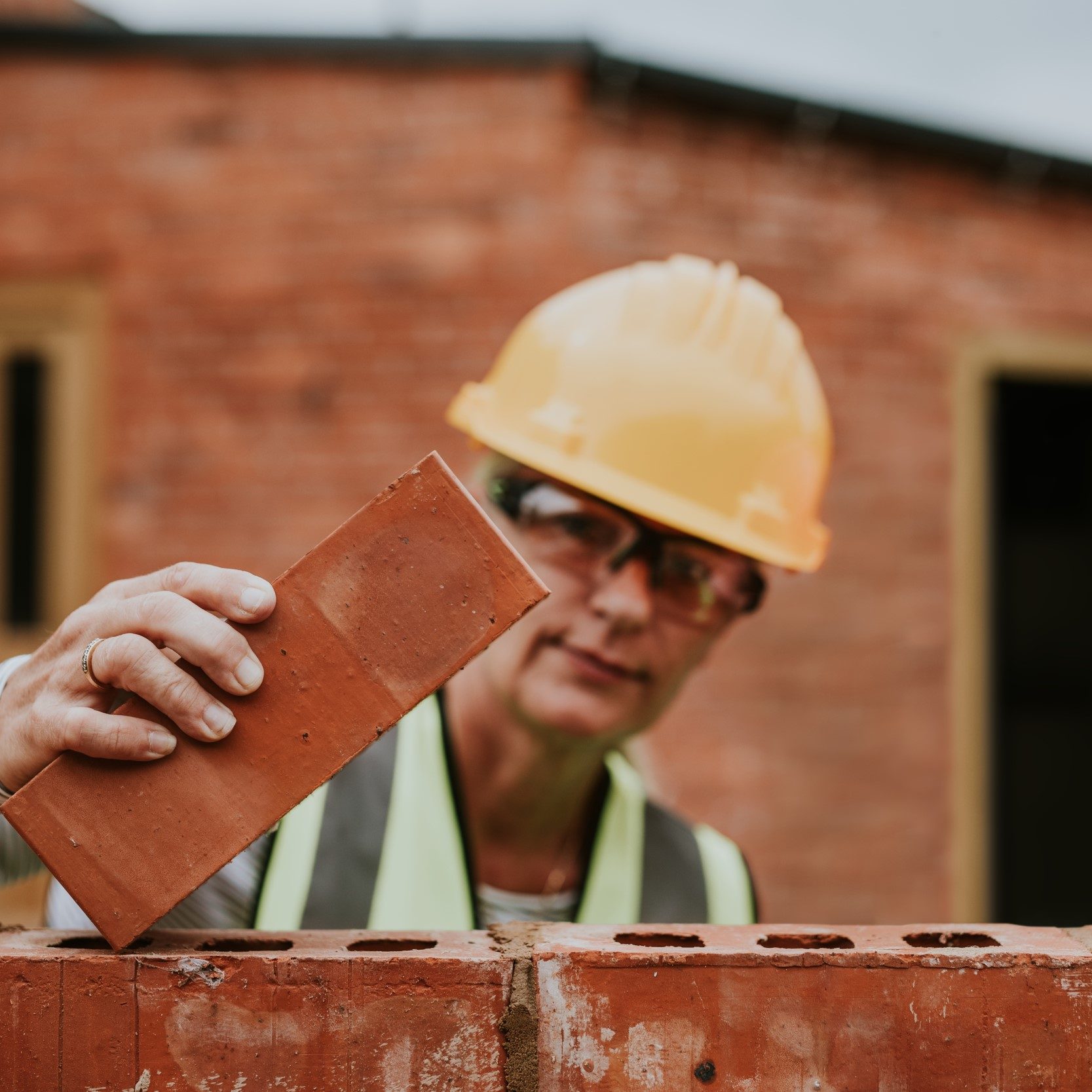 woman-contactor-laying-bricks-outside-home woman-contactor-laying-bricks-outside-home